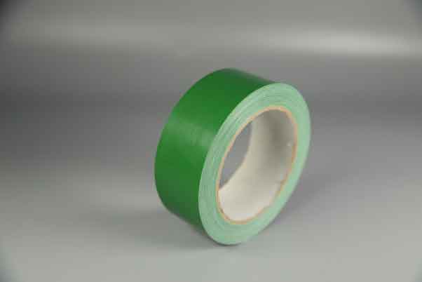单卷绿色的布基胶带摆放在灰色的布上
